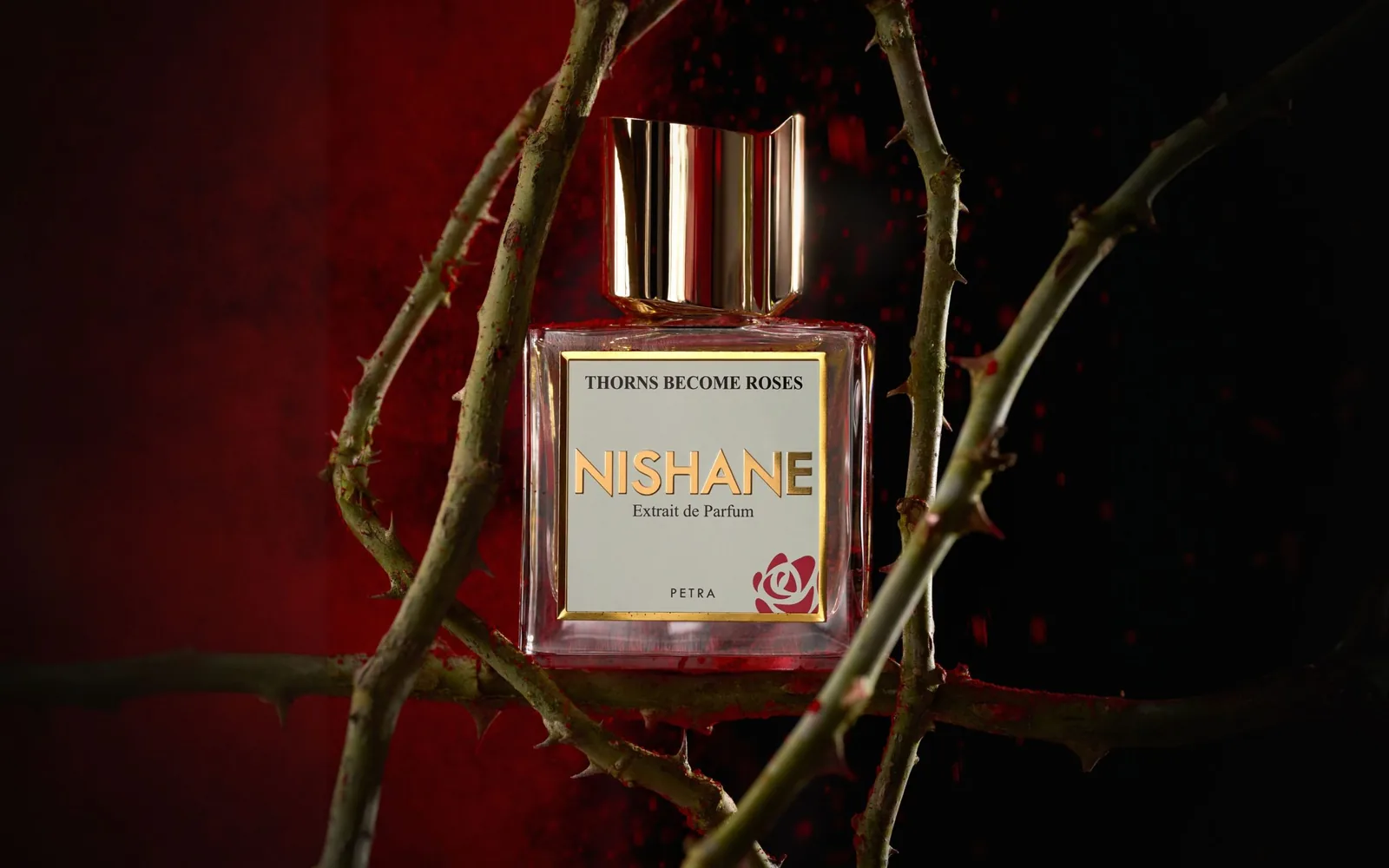 Nishane Thorns Become Roses şişesi, dikenli dallar arasında